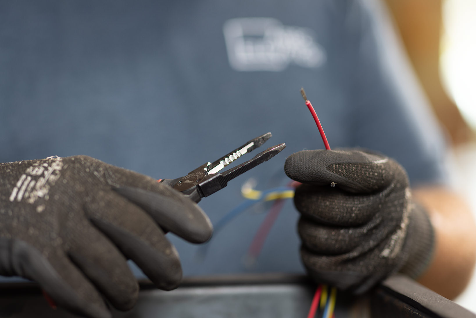 Technician performing precision maintenance on a commercial elevator control panel